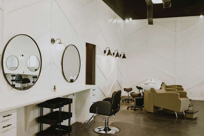 Modern hair salon interior with stylish mirrors and comfortable chairs.